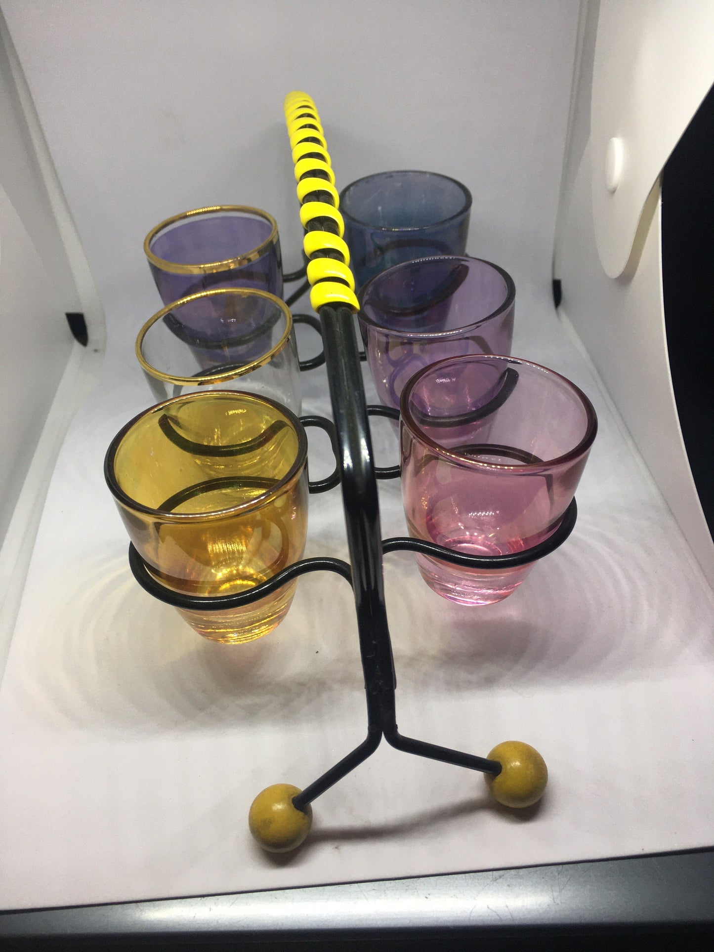 1950s Harlequin glass 6 shot glasses in wire holder.