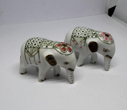 Tiny pair ceramic elephants in ceremonial dress with floral head dress.