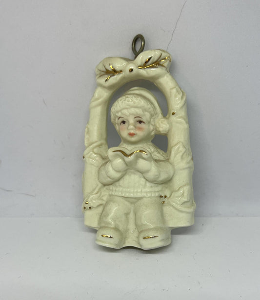 Vintage bisque Christmas tree decoration. Child on a swing reading a book.