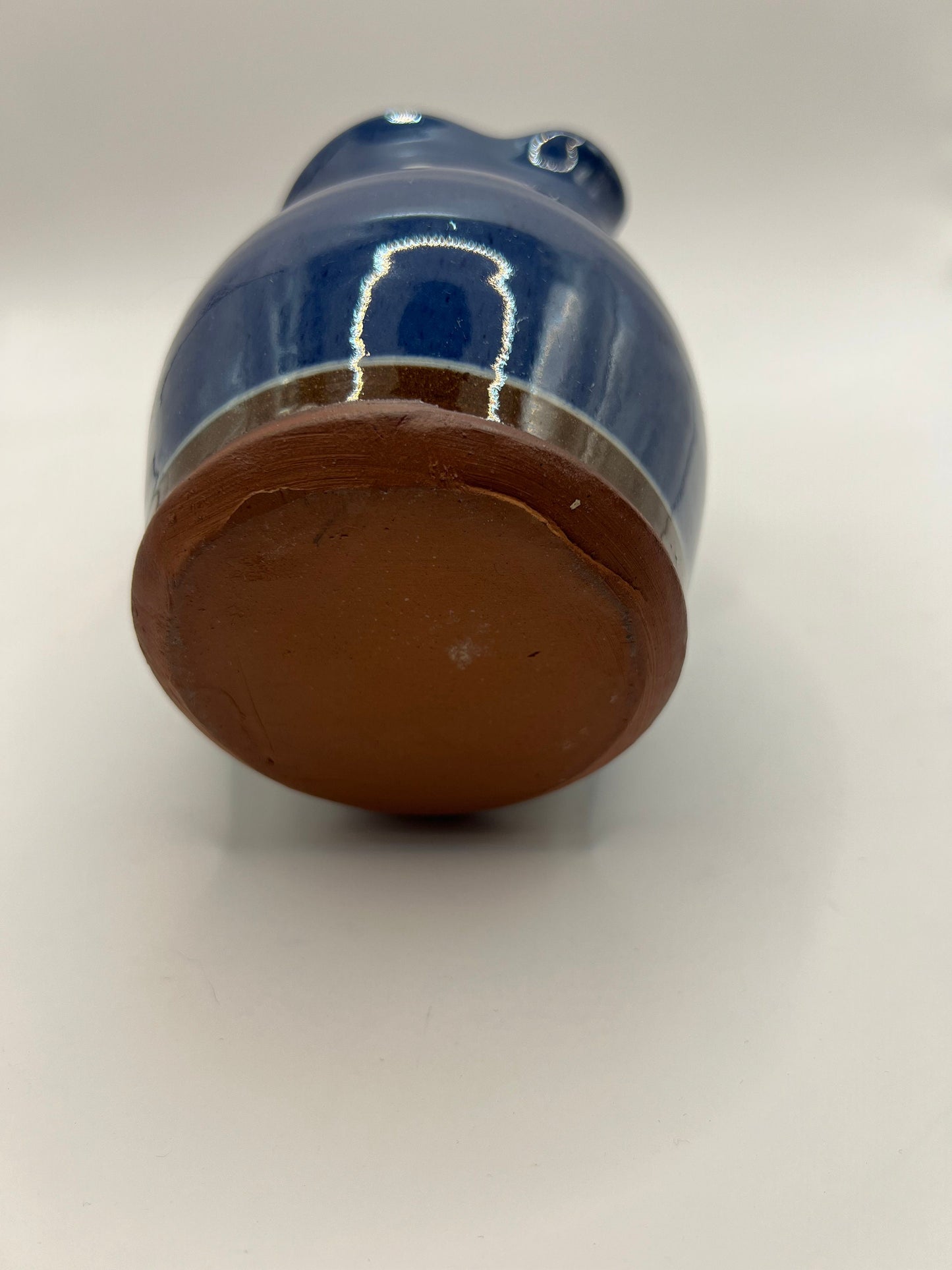 Studio pottery terracotta blue glazed milk water jug. White leaf detail.