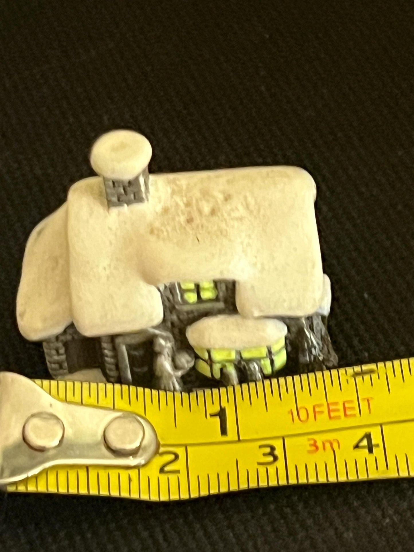 Miniature solid metal cast ornament snow covered Victorian shop.