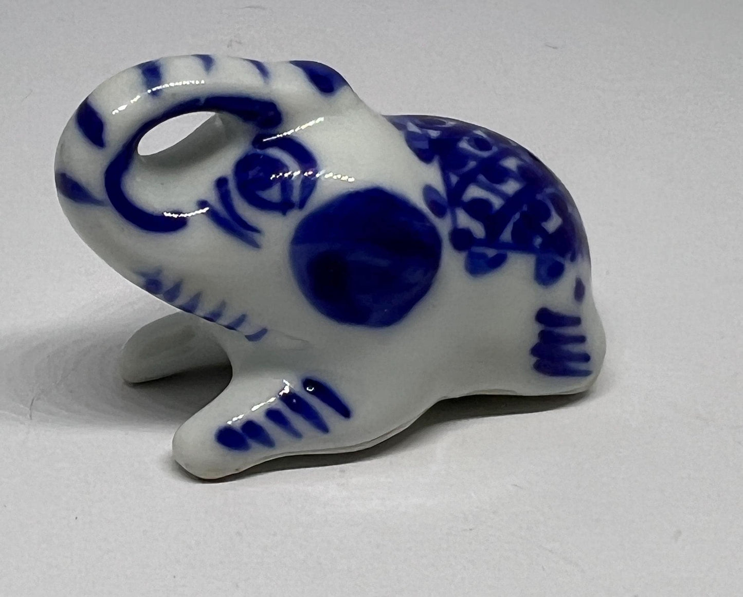 Blue white ceramic elephant figurine. Lucky trunk up sitting elephant ornament.