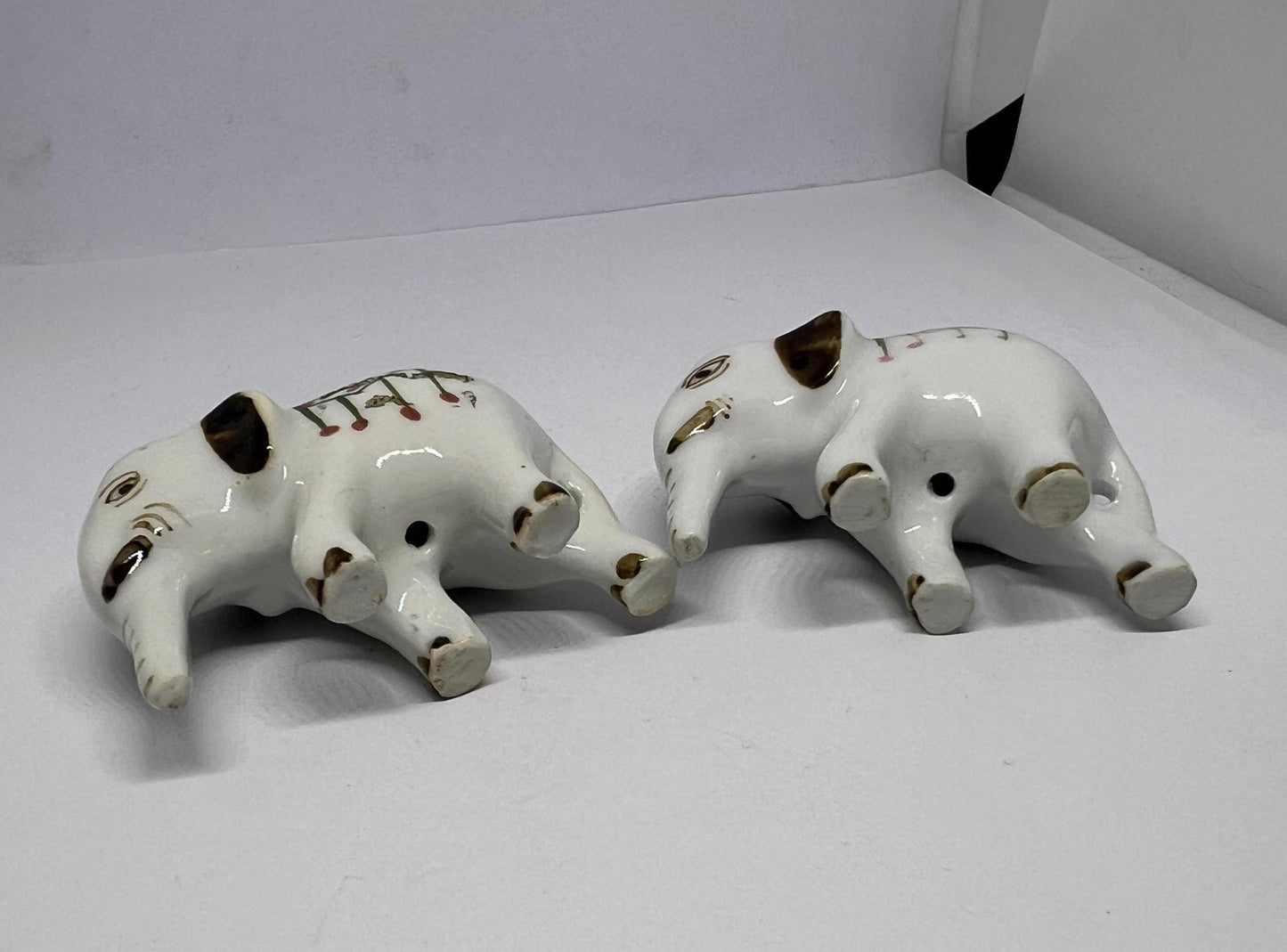 Tiny pair ceramic elephants in ceremonial dress with floral head dress.