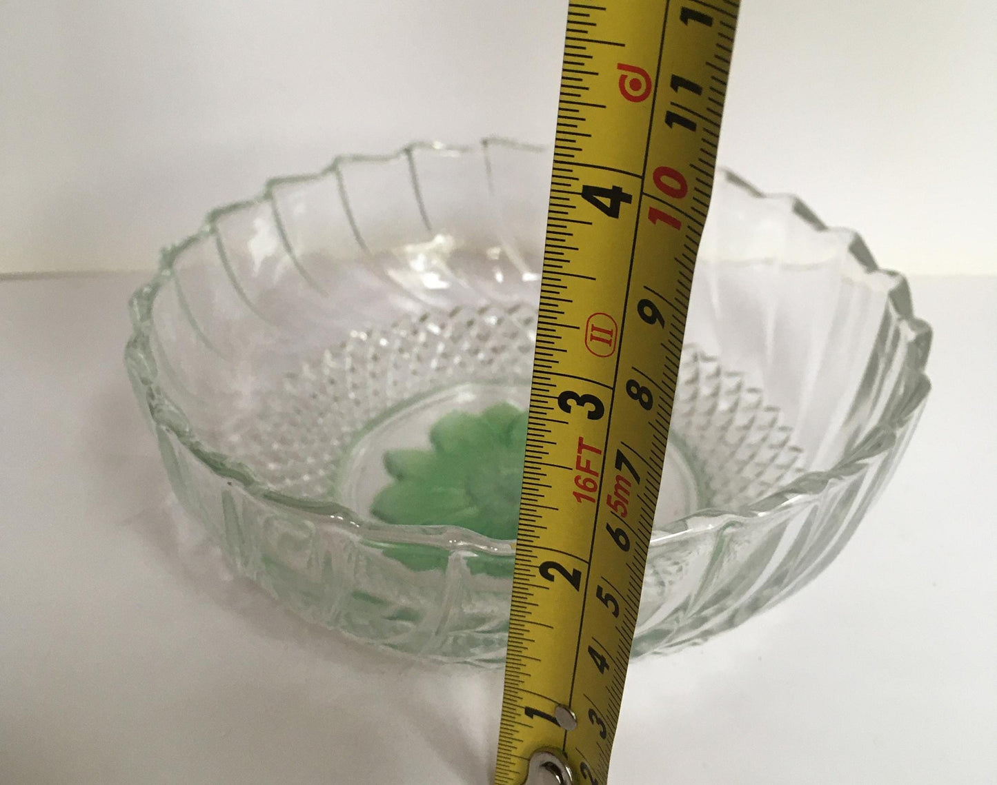 Vintage pressed glass trinket ring dish with green flower detail.