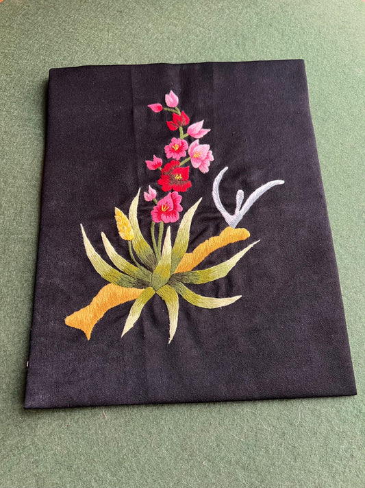 Hand embroidered floral panel. Vintage textile pink red flowers on black cloth.